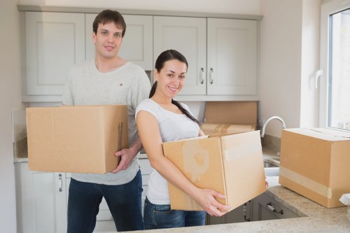 Removal crew transporting office boxes through a South London office building